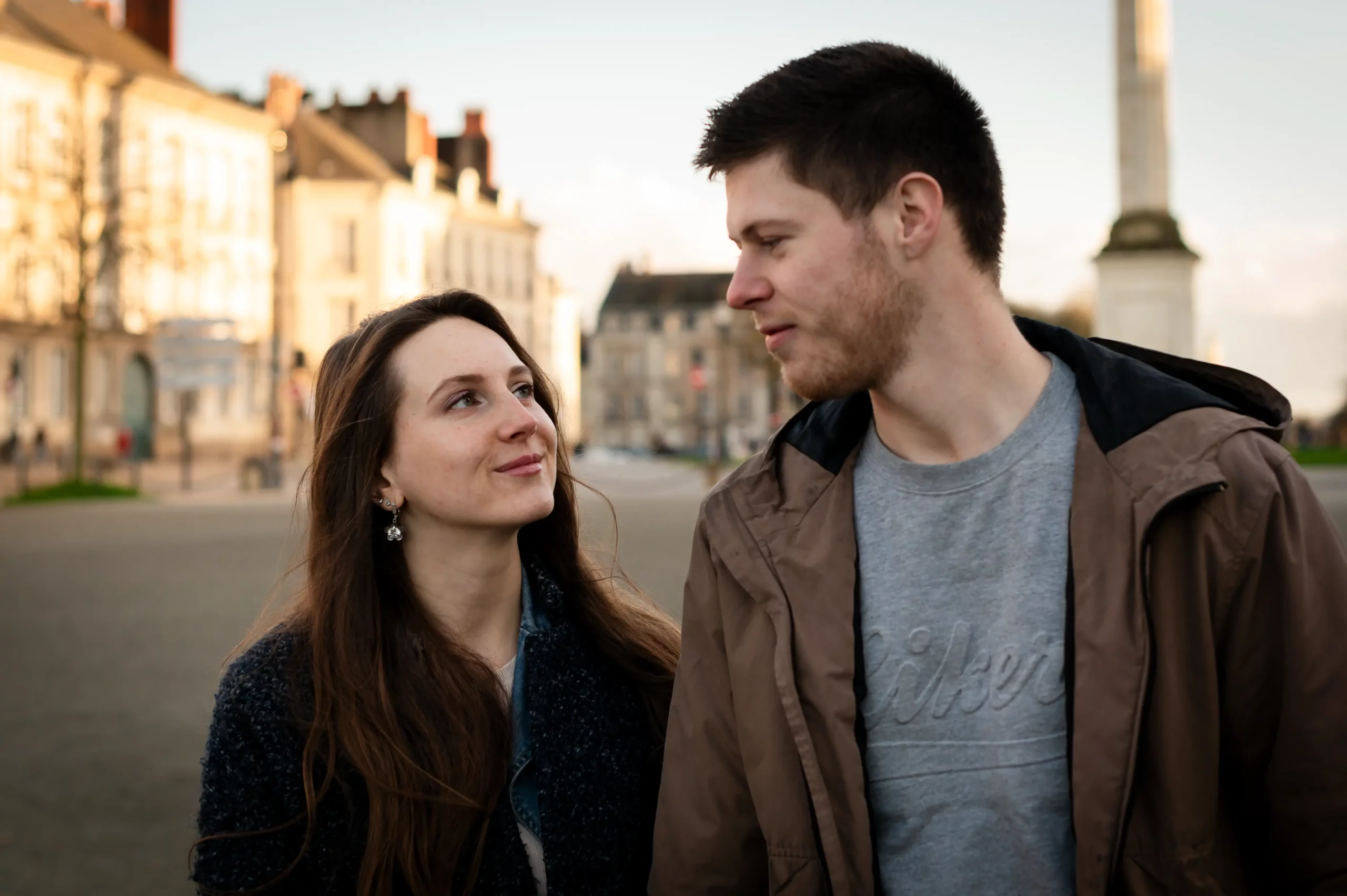 un jeune couple se promene dans le centre ville de nantes, en fin de journée, sous la jolie lumière de la golden hour