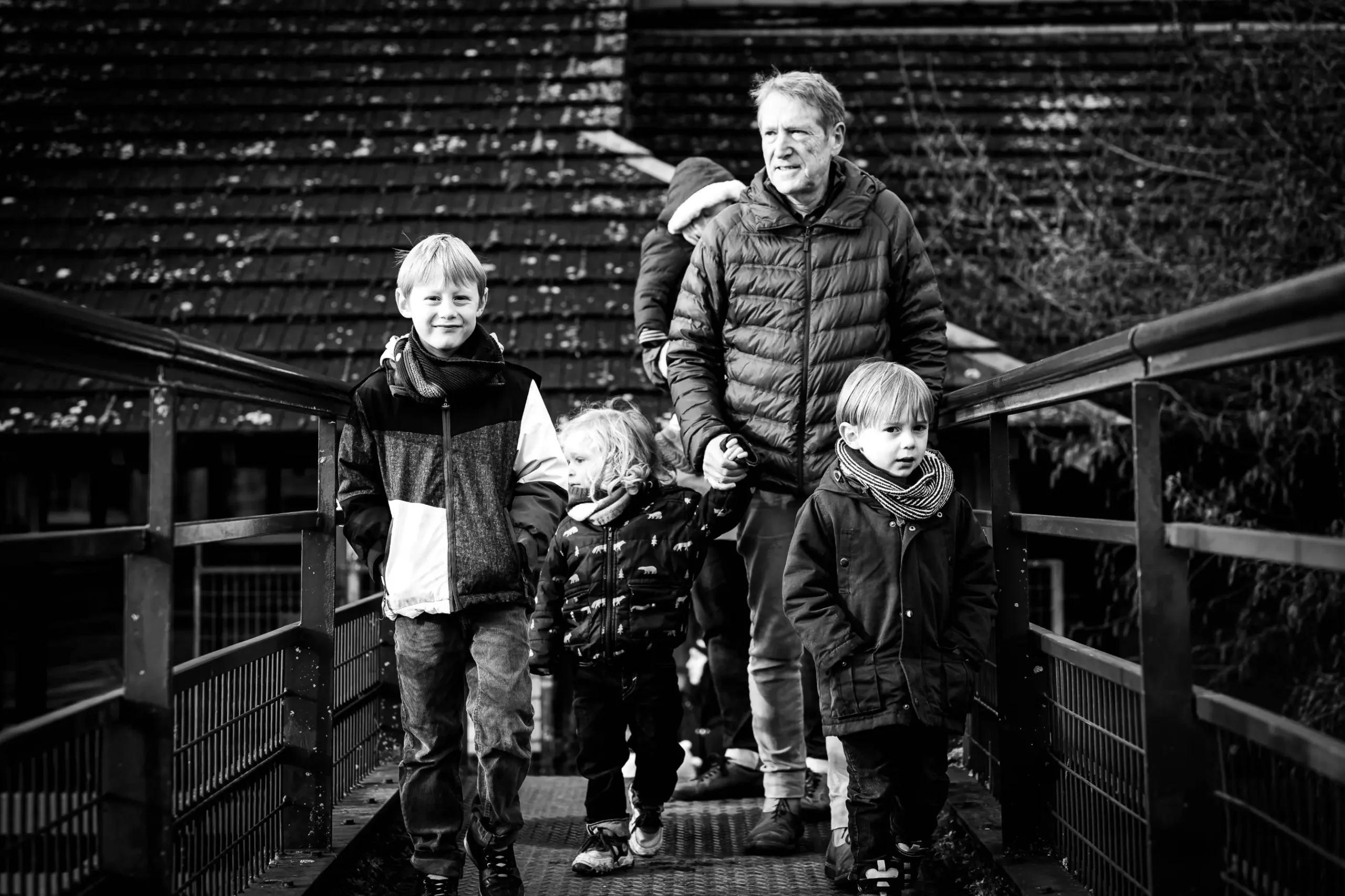 offrir un repotage photo, comme la démarche de ce couple de grands parents, qui a souhaité un reportage avec leur famille à noël. cette photo montre le grand père avec ses petits enfants sur la passerelle de l'île de Versailles à Nantes