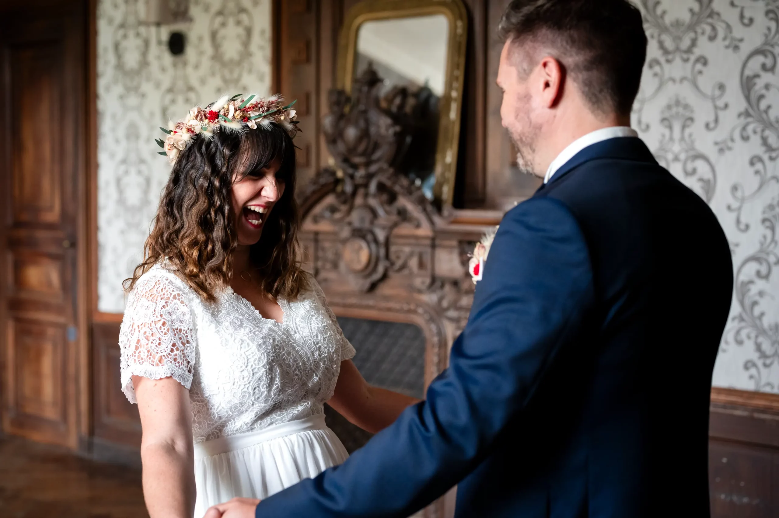 photograpge documentaire de mariage, photo prise pendant le first look d'un mariage. les mariés se découvrent et se tendant les bras avec un grand sourire