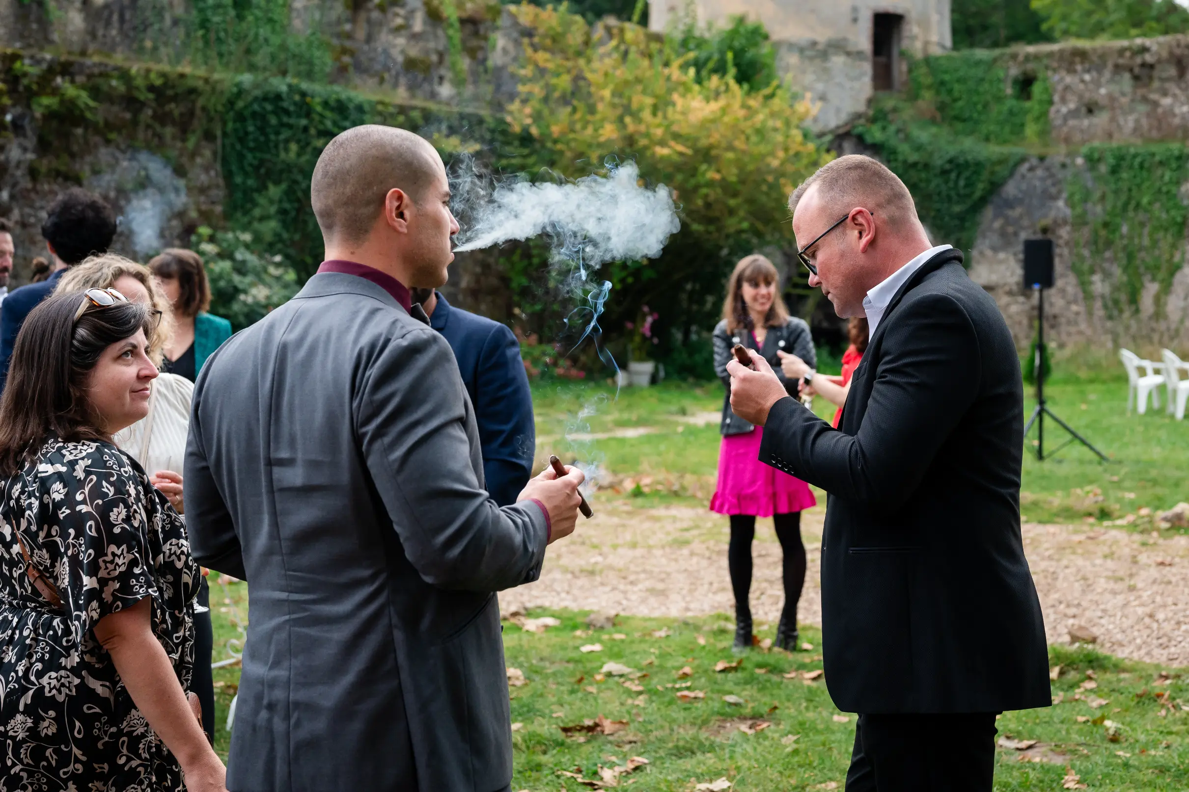 au début du cocktail, deux invités fument leur cigare.