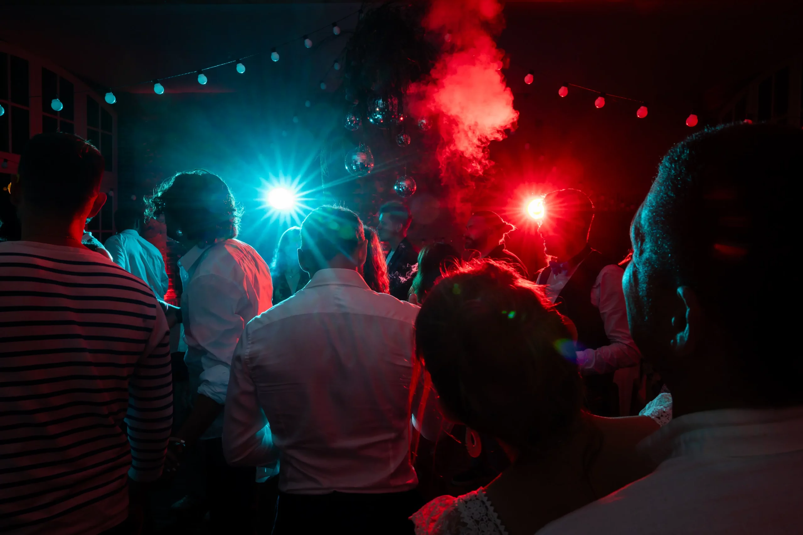 photographie documentaire de mariage pendant la soirée du mariage sous les flashs bleu et rouge du photographequi donne une ambiance moderne