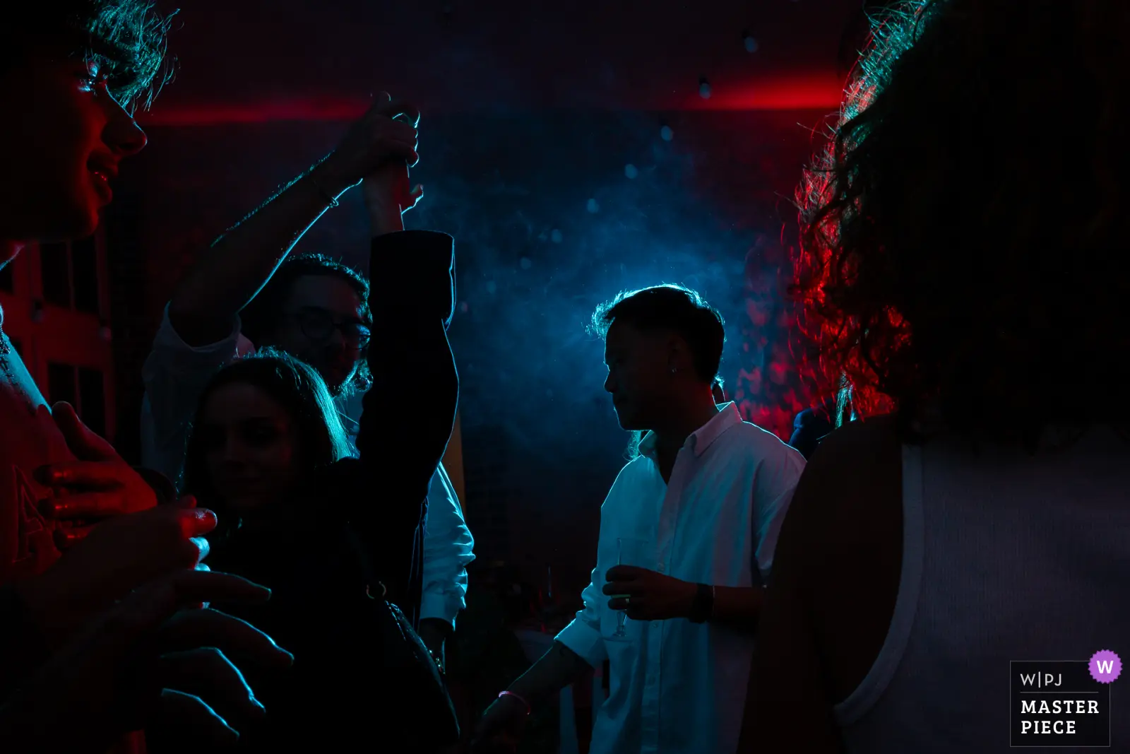 photographe documentaire de mariage, membre de la wpja. photo prise lors de de la soirée sous les flashs bleu et rouge de kévin marzin le photographe